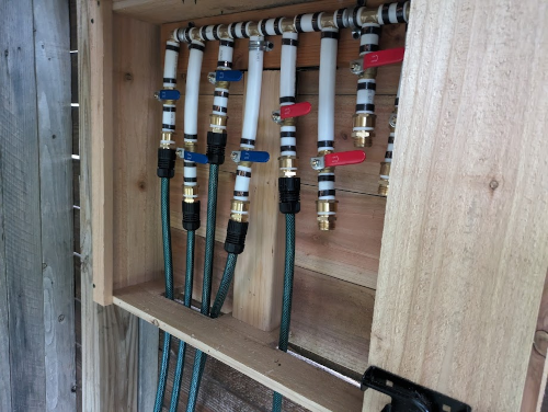 Box mounted to a fence post with some hoses attached